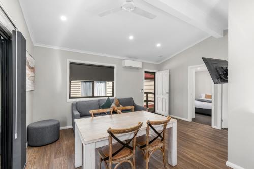 a living room with a table and chairs and a couch at Moss Vale Village Park in Moss Vale