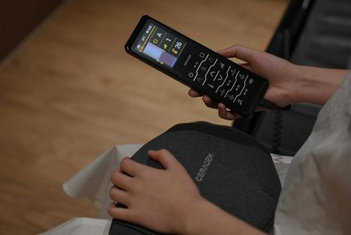 a person holding a remote control in their hand at Aank Ryokan Hotel Ansan Seonbu Branch in Ansan