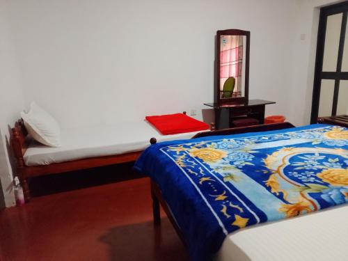 a bedroom with a bed with a blue comforter at Green Villa in Nuwara Eliya