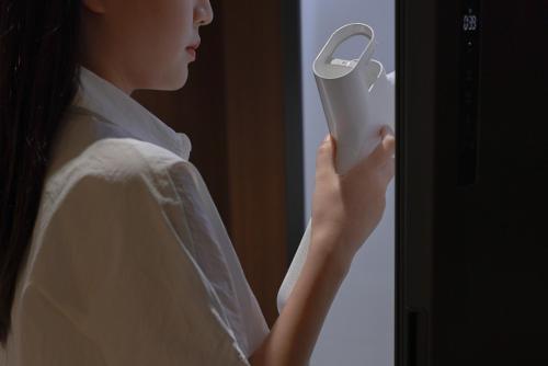 a woman in white shirt looking through a window at Aank Ryokan Hotel Ansan Seonbu Branch in Ansan