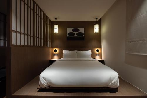 a bedroom with a white bed and two lamps at Aank Ryokan Hotel Ansan Seonbu Branch in Ansan