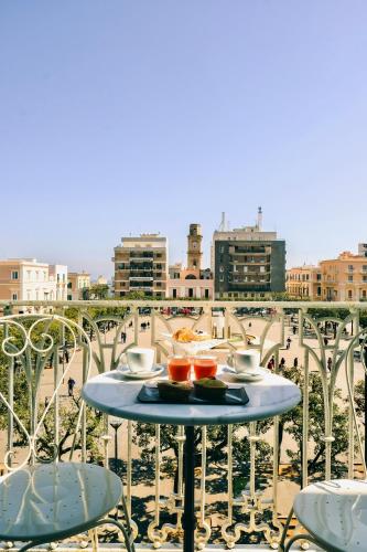 a table with a plate of food on a balcony at Vittorio Emanuele Charming Suites in Monopoli