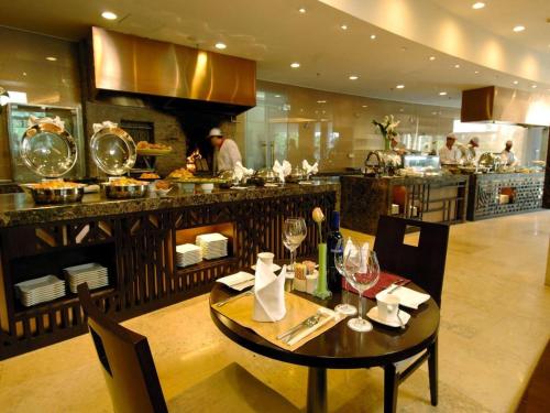 a dining room with a table and a kitchen at Jianguo Garden Hotel in Beijing