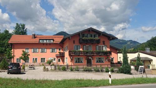 a large orange building with flowers on the front at Hotel Garni Forsthaus Ruhpolding in Ruhpolding