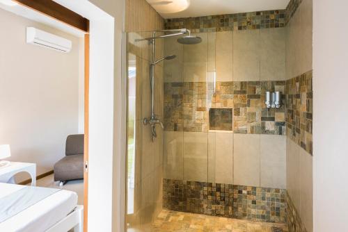 una ducha con puerta de cristal en un baño en Kisana Residence - Pleasant apartment with pool, close to beach, en Pointe aux Cannoniers