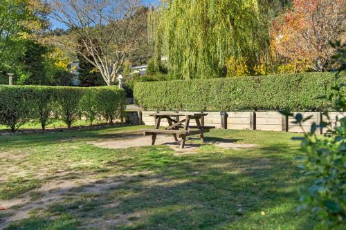 a picnic table in a park next to a hedge at Tasman Holiday Parks Picton in Picton