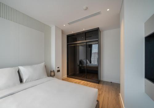 a bedroom with a white bed and a large window at The28 Residence in Hanoi