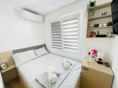 a small bedroom with a bed and a window at The Secret Tale in Varna City