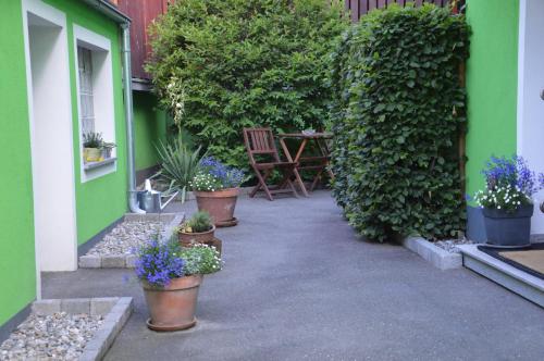 a patio with potted plants and a table and chairs at City Apartment Vasiri in Knittelfeld