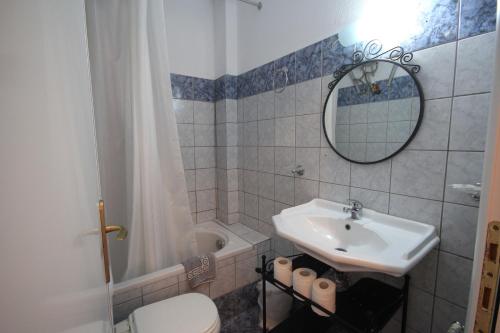 a bathroom with a sink and a toilet and a mirror at Eden Apartments in Neo Klima