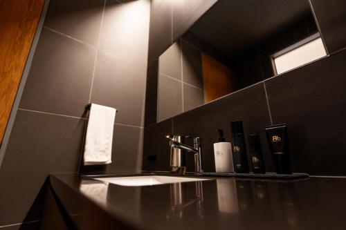 a black bathroom with a sink and a mirror at 郷音 The Summit Club in Tsuru 