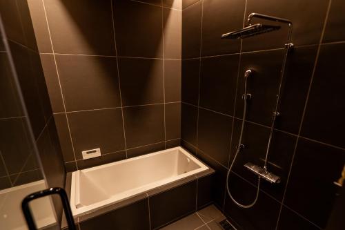 a bathroom with a bath tub and a shower at 郷音 The Summit Club in Tsuru 