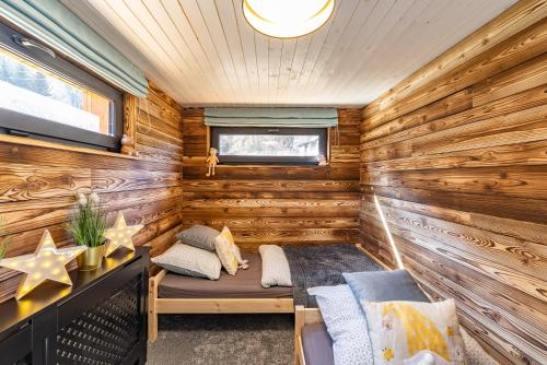 a log cabin with a bed in a room at Chata u lanovky Pustevny in Trojanovice