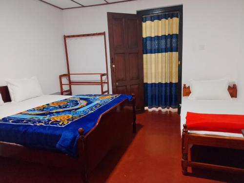 a bedroom with two beds and a chair in it at Green Villa in Nuwara Eliya