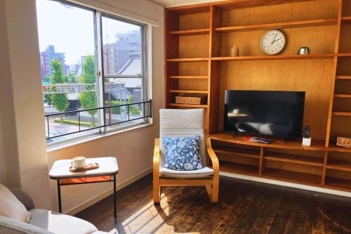 a living room with a tv and a chair and a clock at Ivy Cottage 3F - Vacation STAY 42187v in Kumamoto