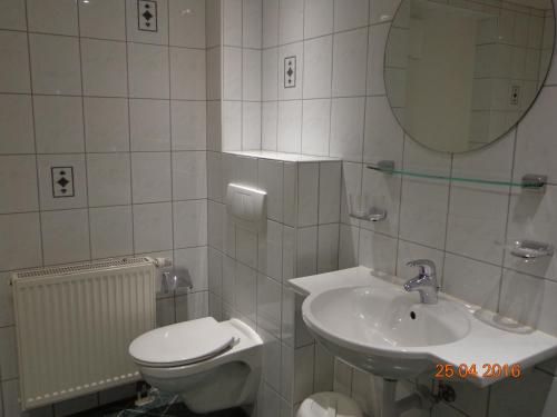 a bathroom with a toilet and a sink and a mirror at Gästehaus Flörl in Gerlosberg