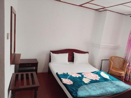 a small bedroom with a bed and a table at Green Villa in Nuwara Eliya