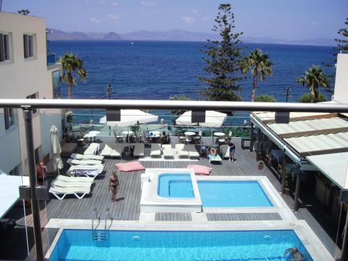a balcony with a swimming pool and the ocean at Bristol Sea View Apartments in Kos Town