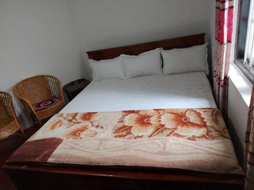 a bedroom with a bed with a flower blanket on it at Green Villa in Nuwara Eliya