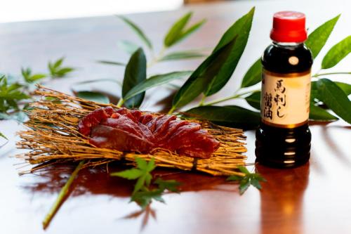 a piece of food on a table next to a bottle of sauce at 郷音 The Summit Club in Tsuru 