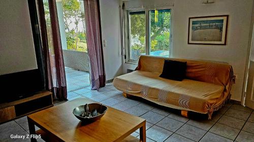 a living room with a couch and a table at Διαμέρισμα με υπέροχη θέα Porto Cheli Kounoupi in Porto Heli