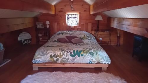 a bedroom with a bed in a cabin at Agréable chalet en bois et son extérieur in Massay