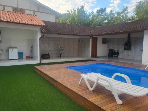 a swimming pool with a white bench next to a house at Aconchego de Piratininga-Niterói Rj in Niterói