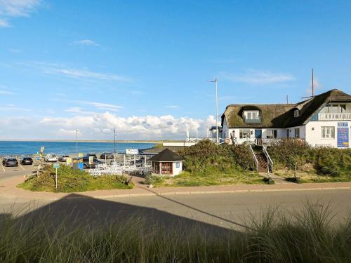 a house on the side of a road next to the ocean at Luxury Pool House near Beach - By Traum Ferienwohnungen in Klitmøller