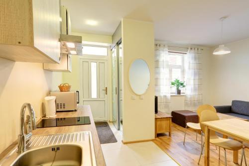 a kitchen and living room with a couch and a table at Hommiku 8a Apartment in Pärnu