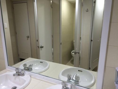 a bathroom with two sinks and a large mirror at Stone House Hotel Pasay in Manila