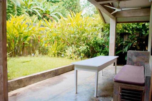 a white table and a chair on a patio at Casa De Moore - Ocean & Garden View Siargao in General Luna
