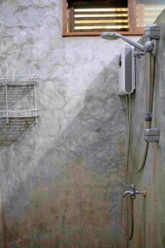 a shower with a hose hooked up to a wall at Casa De Moore - Ocean & Garden View Siargao in General Luna