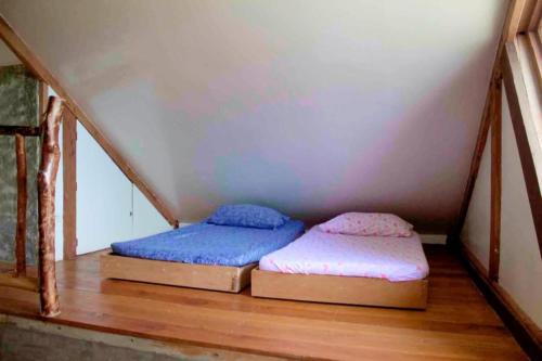 two beds in a room with a attic at Casa De Moore - Ocean & Garden View Siargao in General Luna