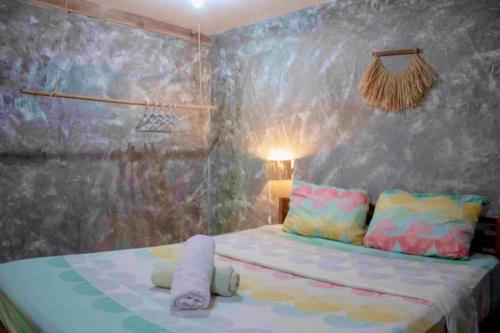 a bedroom with a bed with a painting on the wall at Casa De Moore - Ocean & Garden View Siargao in General Luna