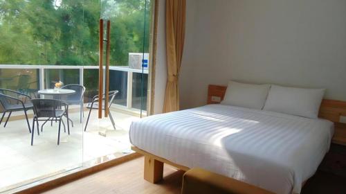 a bedroom with a bed and a balcony with a table at An Hotel Jakarta in Jakarta