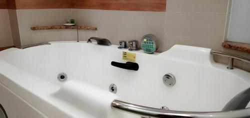 a white bath tub in a bathroom with a sink at An Hotel Jakarta in Jakarta