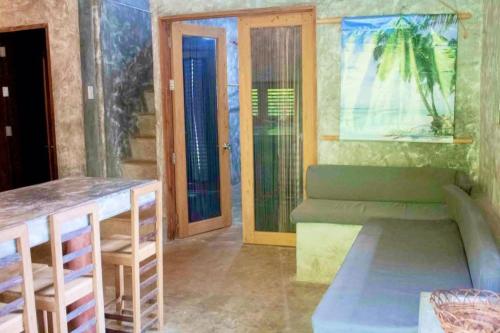 a living room with a couch and a table at Casa De Moore - Ocean & Garden View Siargao in General Luna