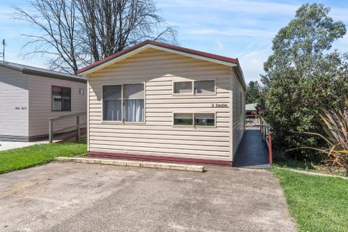 a small white house with a garage at Moss Vale Village Park in Moss Vale