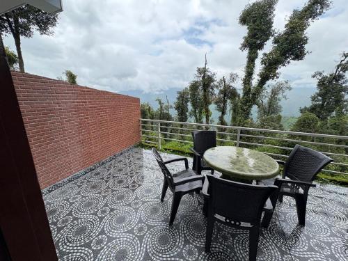 a patio with a table and chairs and a fence at Pacific Inn Mussoorie in Mussoorie