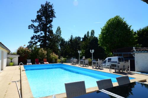 una grande piscina con sedie e tavolo di La Maison Blanche a Romanèche-Thorins