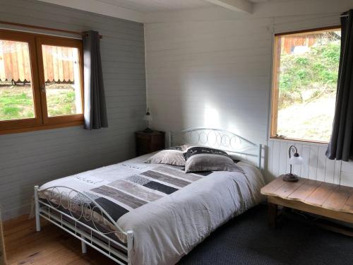 una camera da letto con un letto e una finestra di Small house, charming cabin, Cozy place a Montbrun-Bocage