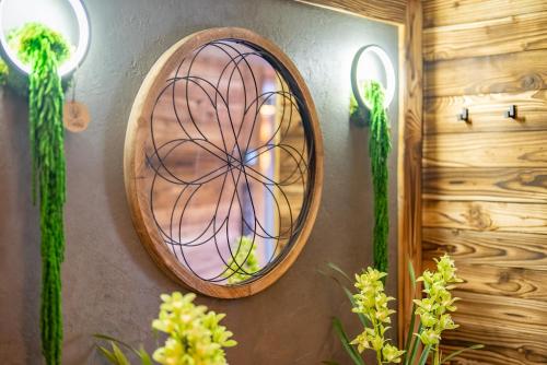 a round mirror on a wall with some plants at Chata u lanovky Pustevny in Trojanovice