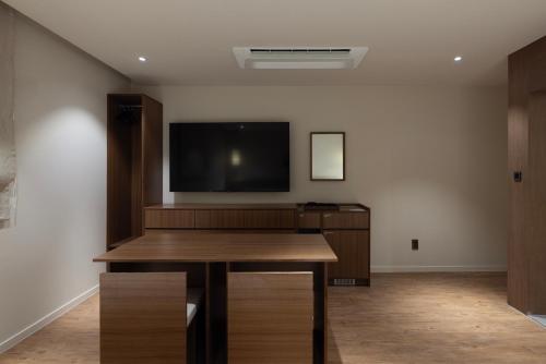 a room with a flat screen tv and a wooden table at Aank Ryokan Hotel Ansan Seonbu Branch in Ansan