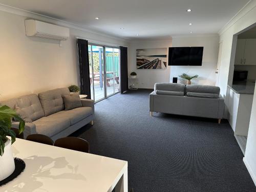 a living room with a couch and a table at The Oaks Hotel Motel in Albion Park