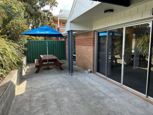 a patio with a picnic table and an umbrella at The Oaks Hotel Motel in Albion Park