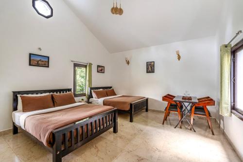 a bedroom with two beds and a table at Interlaken in Yedapalli