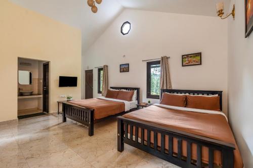 a bedroom with two beds and a tv at Interlaken in Yedapalli