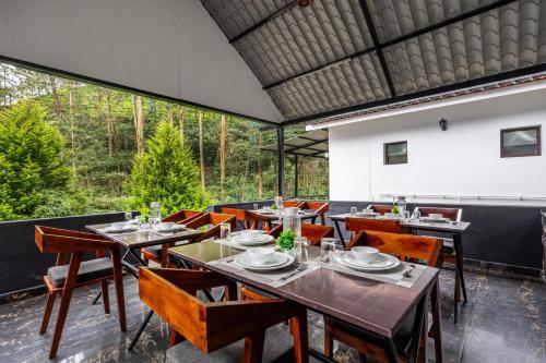 a dining room with tables and chairs and a large window at Interlaken in Yedapalli