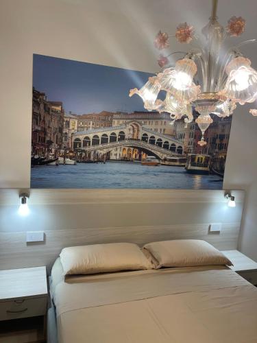a bedroom with a painting of a bridge at Casa sulla Laguna CASTELLO in Venice