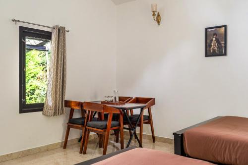 a room with a table and chairs and a bed at Interlaken in Yedapalli